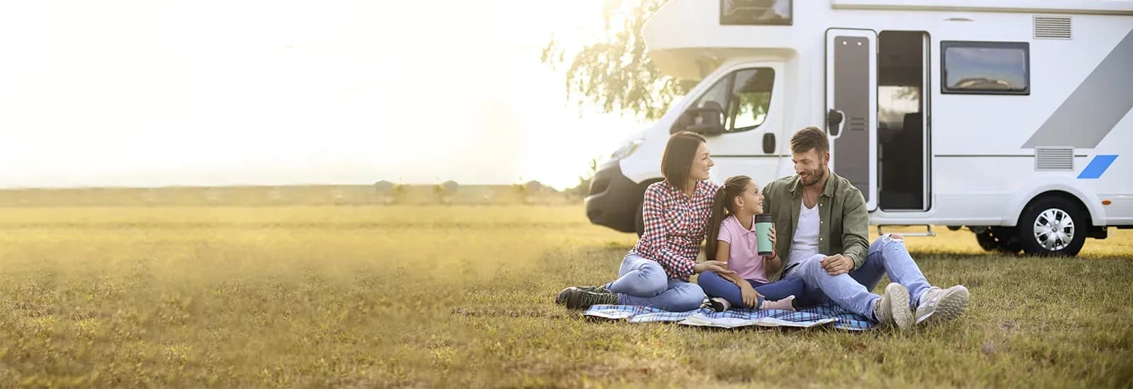 Family relaxing beside their new motorhome